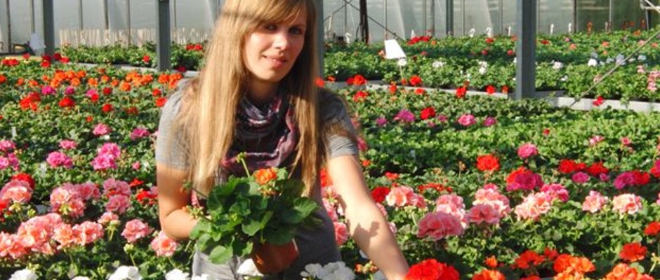 Foto von Lena Sander mit Blumen in der Gärtnerei